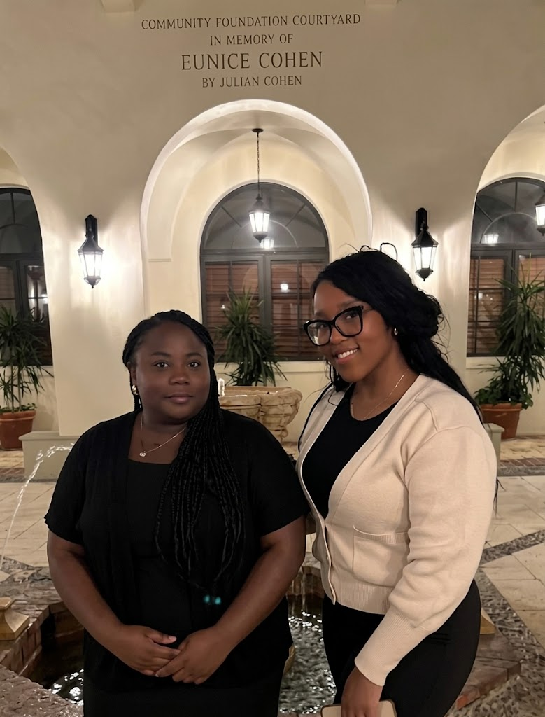 Two Lakou Lokal founders standing together in a lantern-lit courtyard in the evening